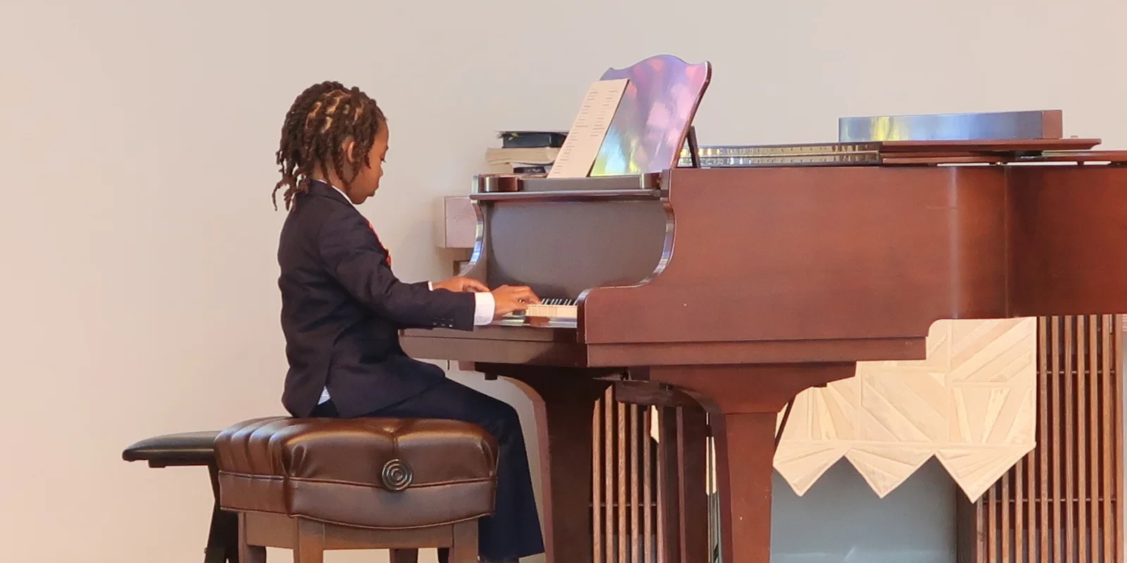 Student performing at a grand piano