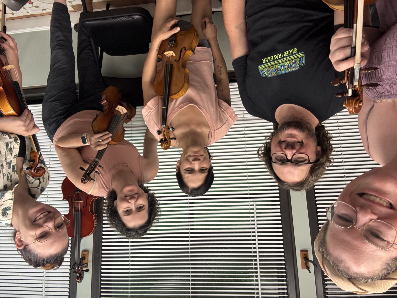 A group of adults together with their violins at the studio