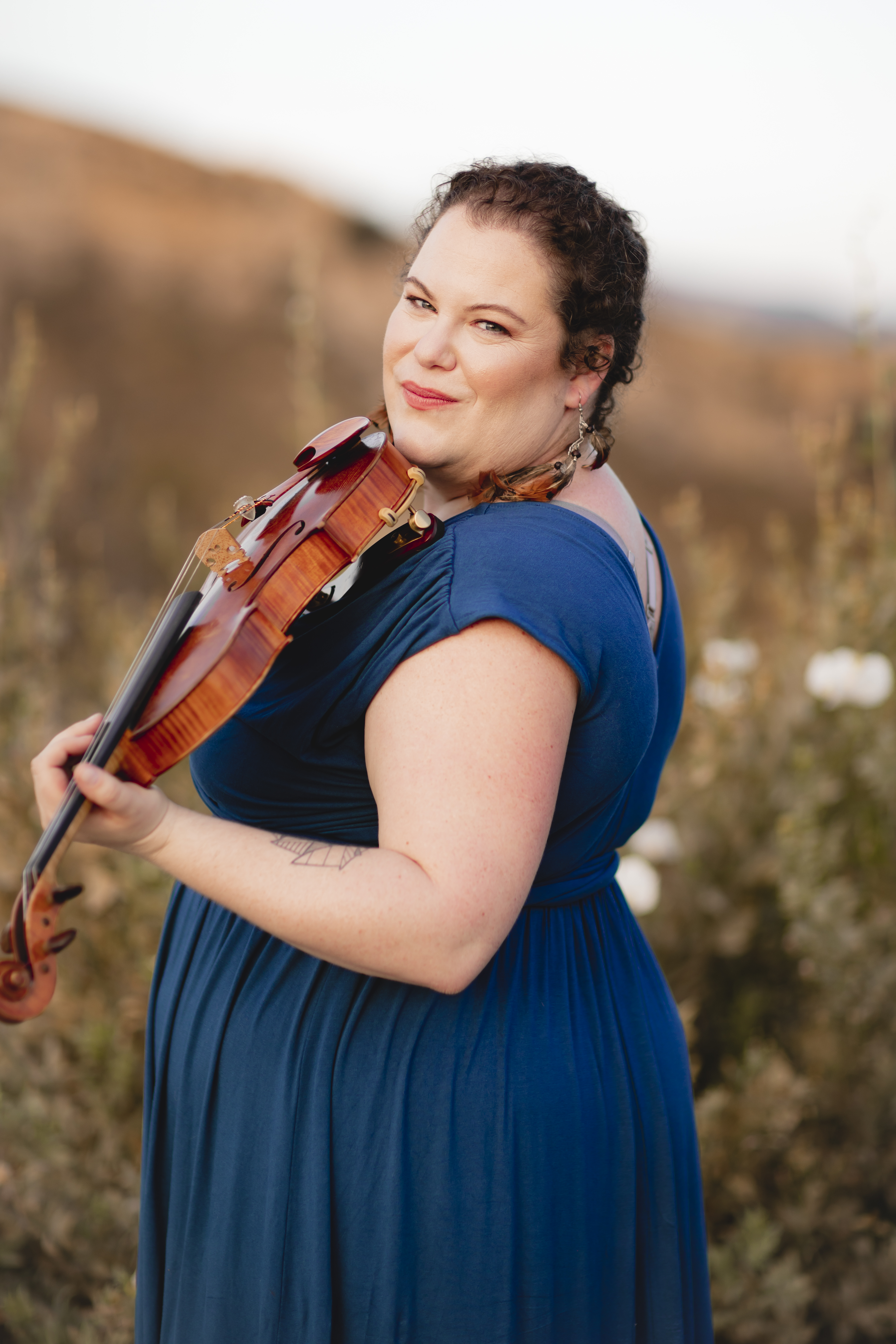 Emily Moore holding her violin outdoors