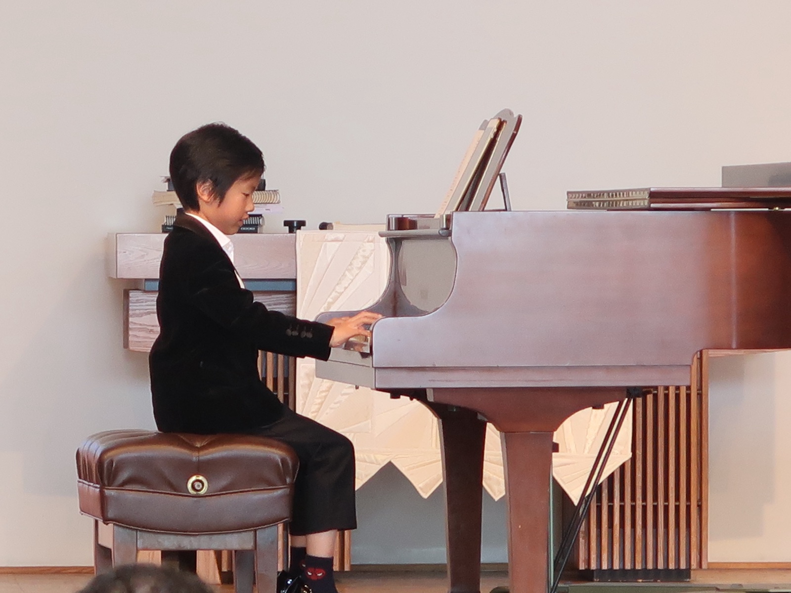 Student performing at a grand piano